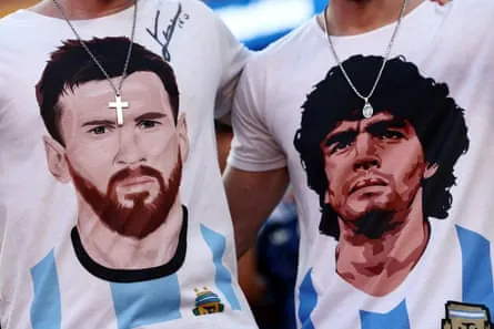 Two fans wear T-shirts with the faces of Lionel Messi and Diego Maradona.